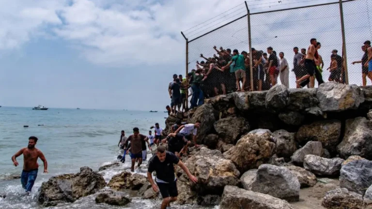 Migrants swimming around the coastal border barrier between Morocco and Ceuta to reach Spanish territory.