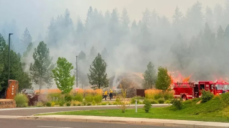 Old Trails Fire burning near the Spokane River as smoke rises over dry vegetation in Spokane, Washington
