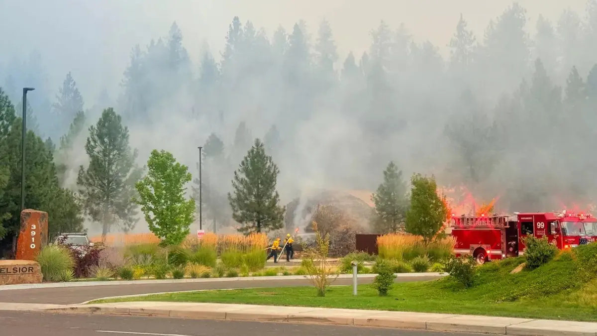 Old Trails Fire burning near the Spokane River as smoke rises over dry vegetation in Spokane, Washington