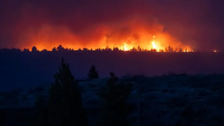 Spokane residents evacuating during a Level 3 wildfire alert as smoke rises near a residential area